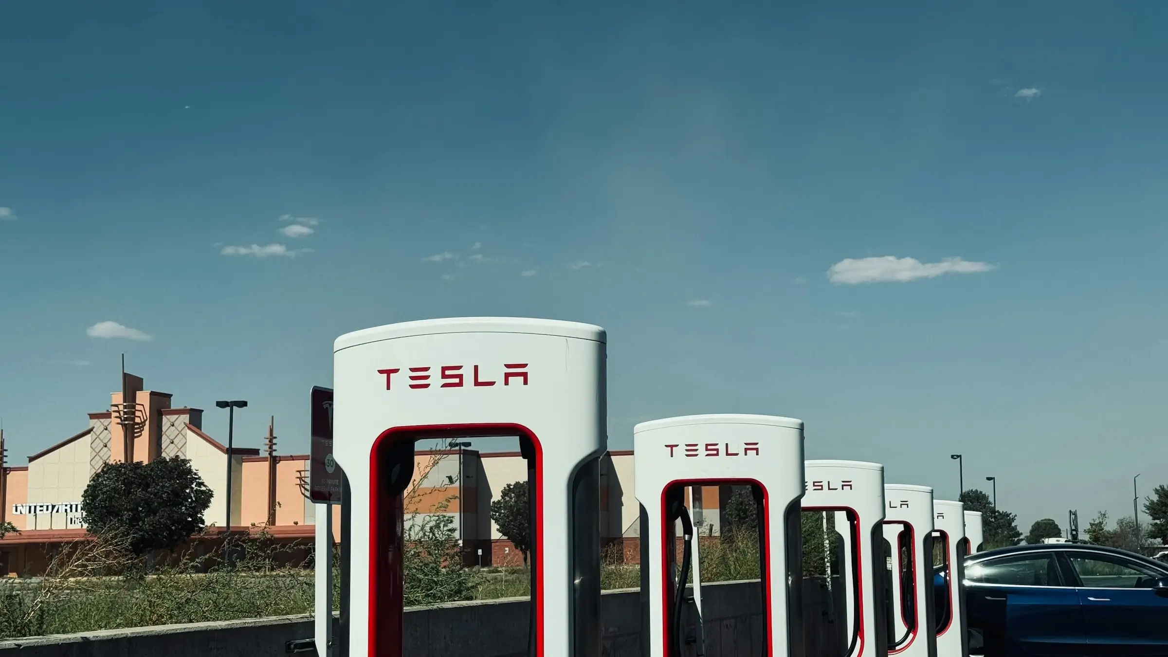 A row of Tesla Superchargers under a wide open sky